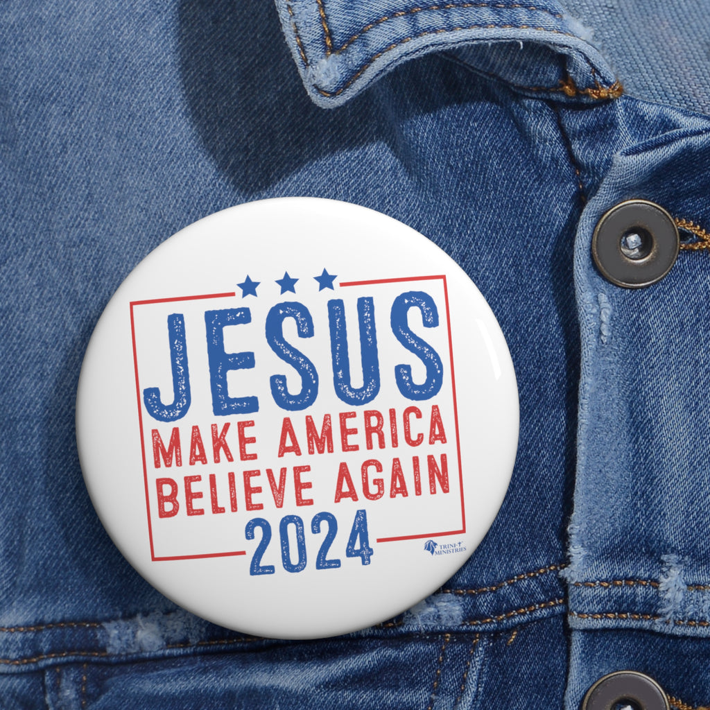 Large Christian 'Jesus 2024' campaign-style button worn on denim jacket lapel. Faith-inspired political parody pin in use.