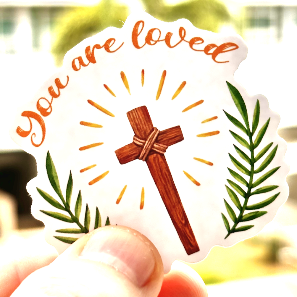 A shining wooden cross surrounded by palm leaves recalling the Good Friday and Easter account of Christ's kingship and great sacrifice in love that saved us all! The message, 'You are loved' -John 15:9 is featured at the top. Ideal for decorating planners, scrapbooks, and more, this sticker brings a message of gratitude and the love of God.