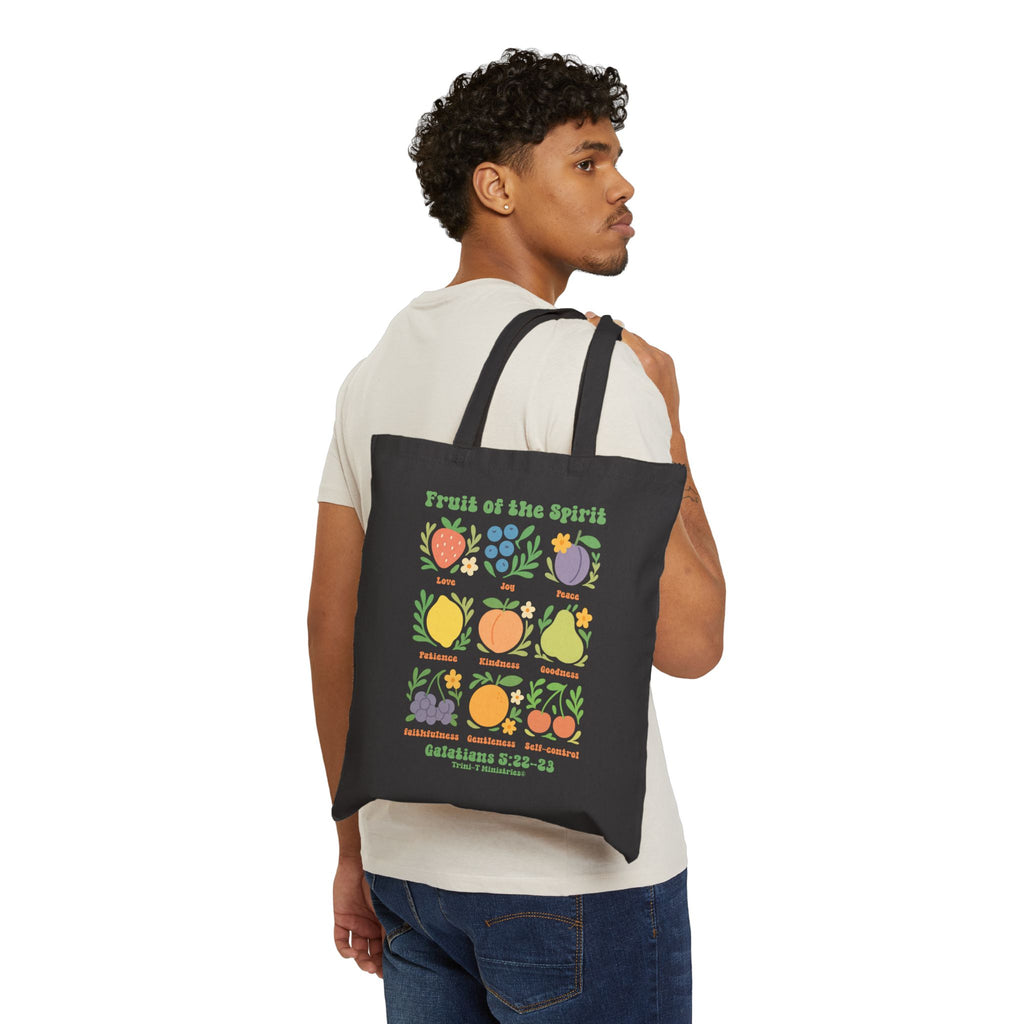 Man carrying Fruit of the Spirit black tote bag.