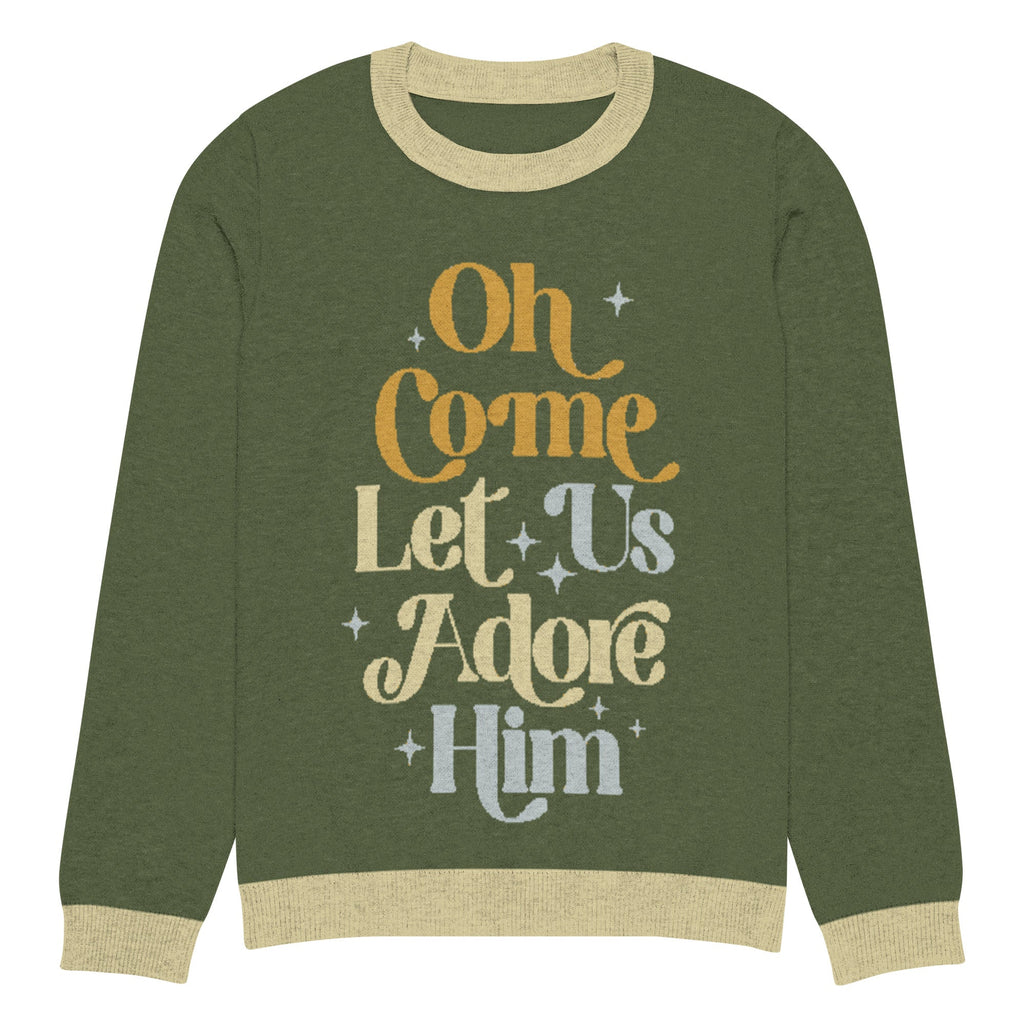 Oh Come Let Us Adore Him' knitted Christmas sweater flat lay, front view, in olive green with beige ribbed collar, cuffs, and hem. Features retro-style text graphic in gold, cream, and gray. Christian-themed ugly Christmas sweater, unisex design, soft and cozy for holiday gatherings.