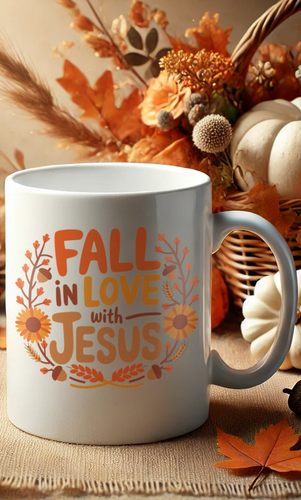 Fall in Love with Jesus Mug surrounded by fall foliage and pumpkins, Christian autumn-themed mug for warm beverages.