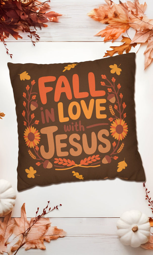 Fall in Love with Jesus throw pillow surrounded by autumn leaves and pumpkins, Christian fall decor, available in sizes 14x14, 16x16, and 20x20 inches.