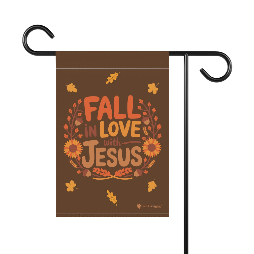 Close-up view of Fall in Love with Jesus garden flag hanging on a stake, Christian fall decor for outdoor display, 12x18 inches.