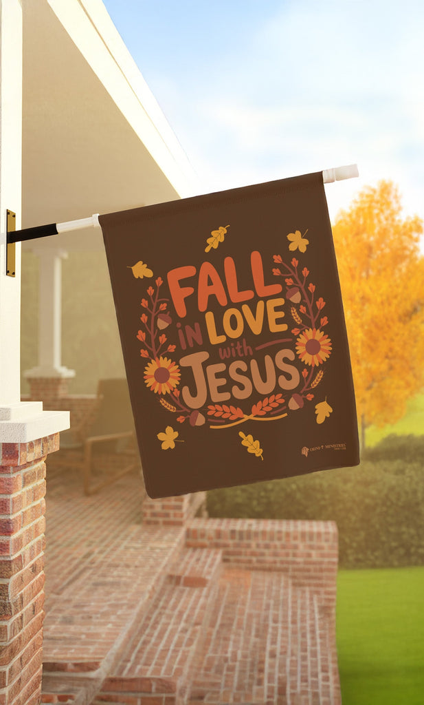 Fall in Love with Jesus house flag hanging on a porch, Christian fall-themed flag for outdoor decor, 24.5x32 inches.