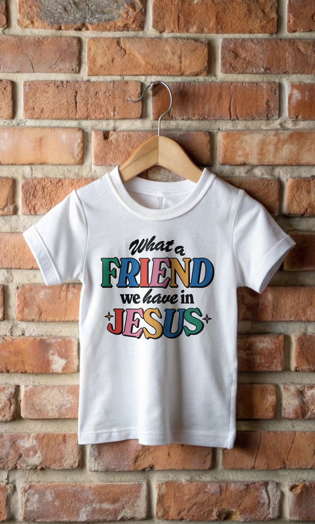 Friend in Jesus White T-Shirt hanging from a brick wall.