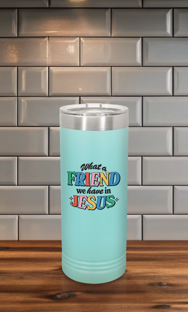 Friend in Jesus - Skinny Tumbler on a kitchen counter with vibrant, multi-colored text reading 'What a Friend we have in Jesus.' Designed by Christian artist Adrián, this tumbler features double-wall vacuum insulation to keep drinks hot or cold for hours. It includes a clear spill-resistant lid and fits most standard cup holders. Perfect for daily use or as a thoughtful Christian gift, this faith-inspired tumbler serves as a stylish reminder of John 15:15 and your friendship with Jesus.