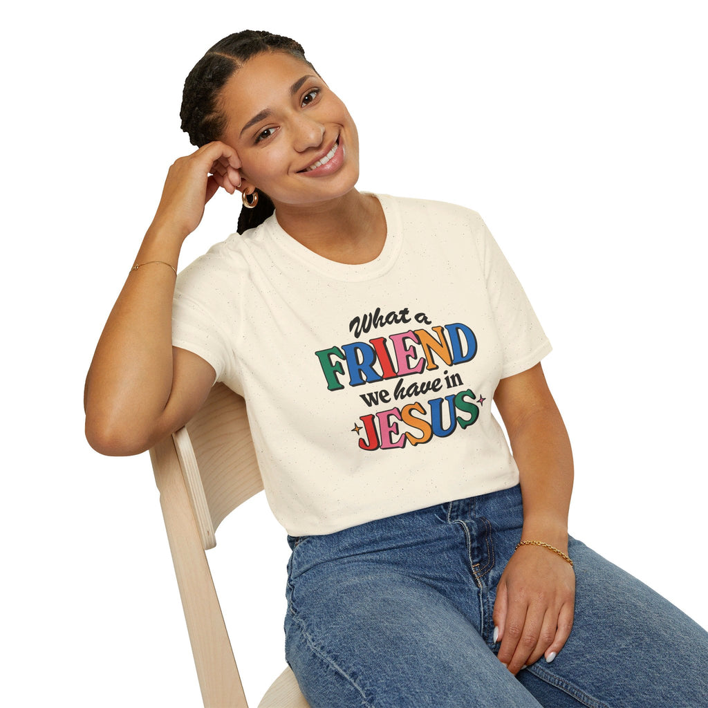 A woman sitting in a chair wearing a Natural Colored Friend in Jesus T-shirt.