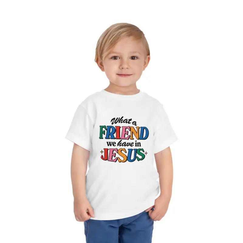 A toddler boy wearing a white Friend in Jesus T-shirt.