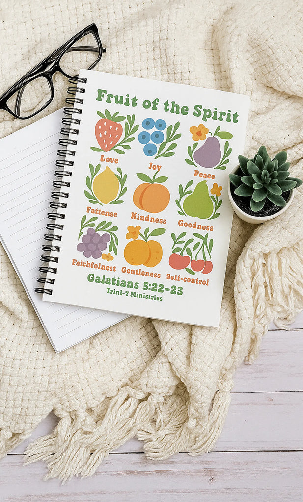 Fruit of the Spirit Journal with Galatians 5:22–23 displayed on a cozy cream blanket with glasses and a plant.