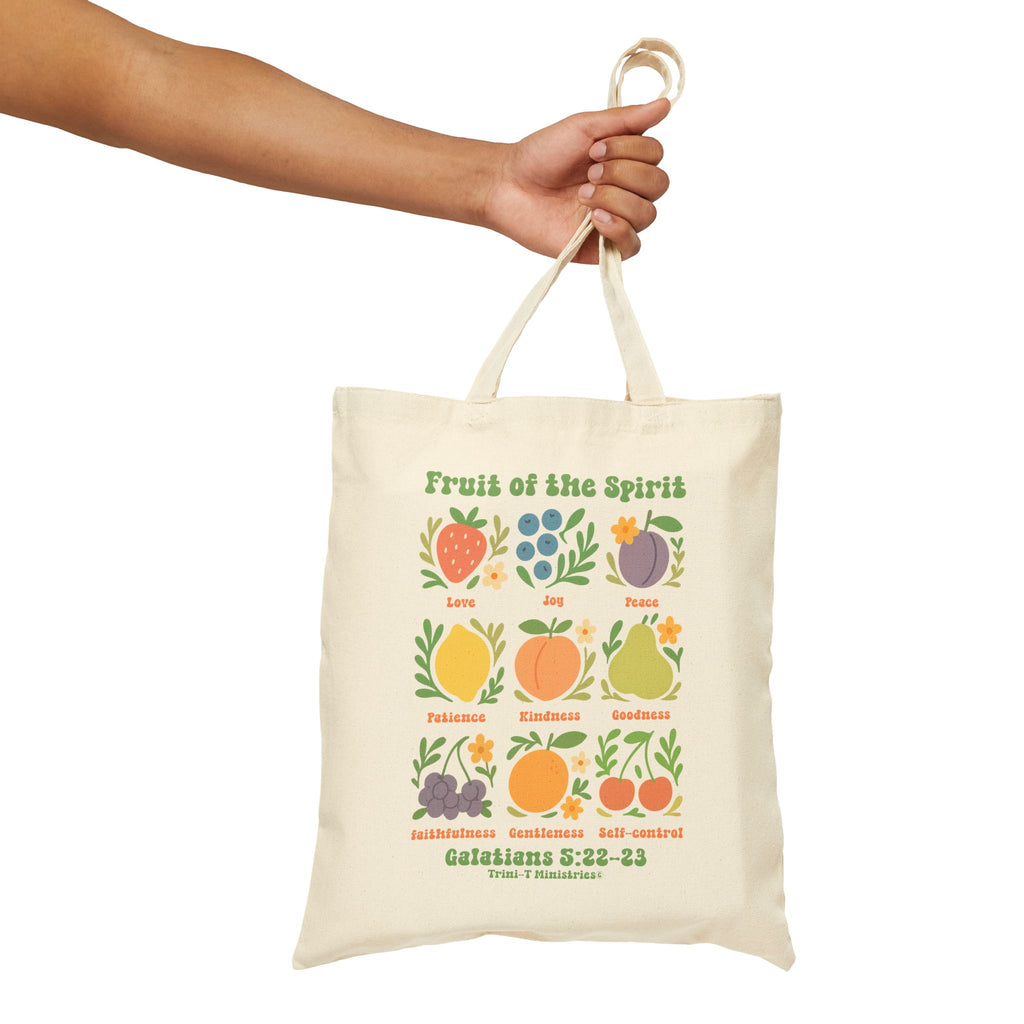 Hand holding a side view of the natural Fruit of the Spirit tote bag.