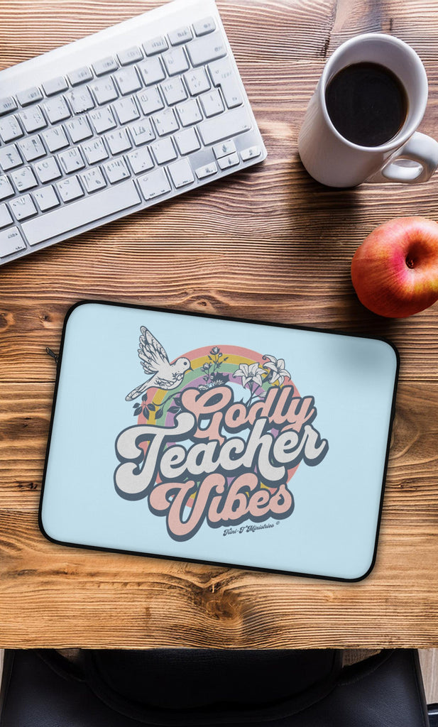 An overhead view of a teacher's desk with the Godly Teacher Vibes Laptop / Tablet Sleeve from Trini-T Ministires.