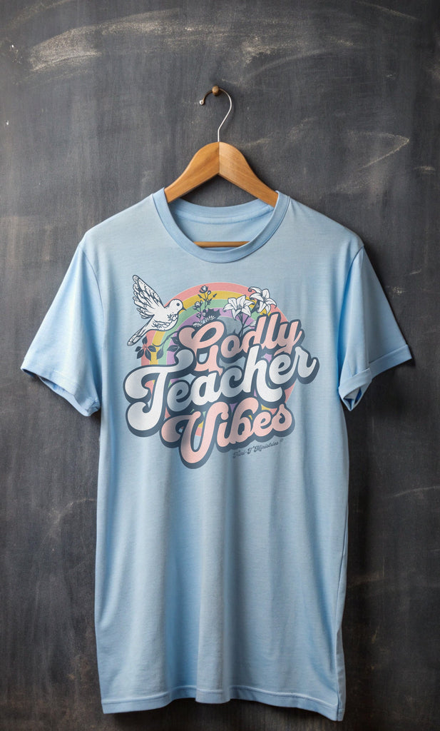 Light Blue Godly Teacher Vibes T-Shirt in front of a chalkboard.  Celebrate the incredible impact of Godly teachers with our new "Godly Teacher Vibes" Collection from Trini-T Ministries!