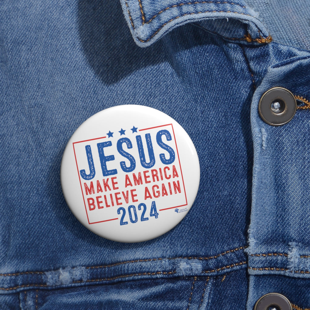 Medium Christian 'Jesus 2024' campaign-style button worn on denim jacket lapel. Faith-inspired political parody pin in use.