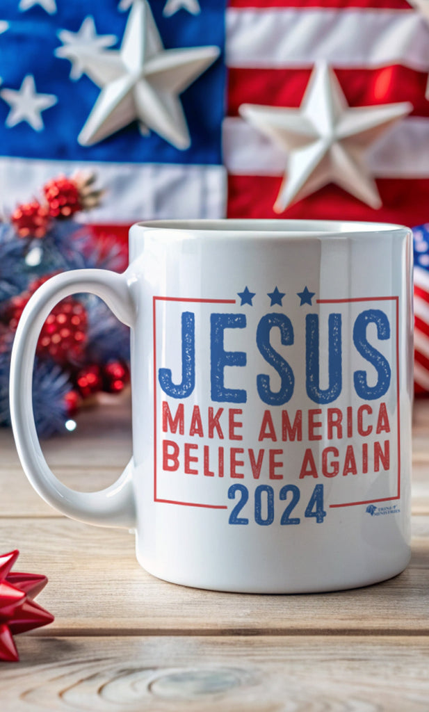 An 11oz Jesus 2024 - Make America Believe Again mug on a wooden table in front of patriotic American decorations. Embrace your faith and share a powerful message with our "Jesus 2024 - Make America Believe Again" 11oz Mug. Designed for Christians who put Jesus above politics and candidates, recognizing Him as our true Savior. This mug blends a playful spoof of political campaigns with a unifying call to believe in Him.