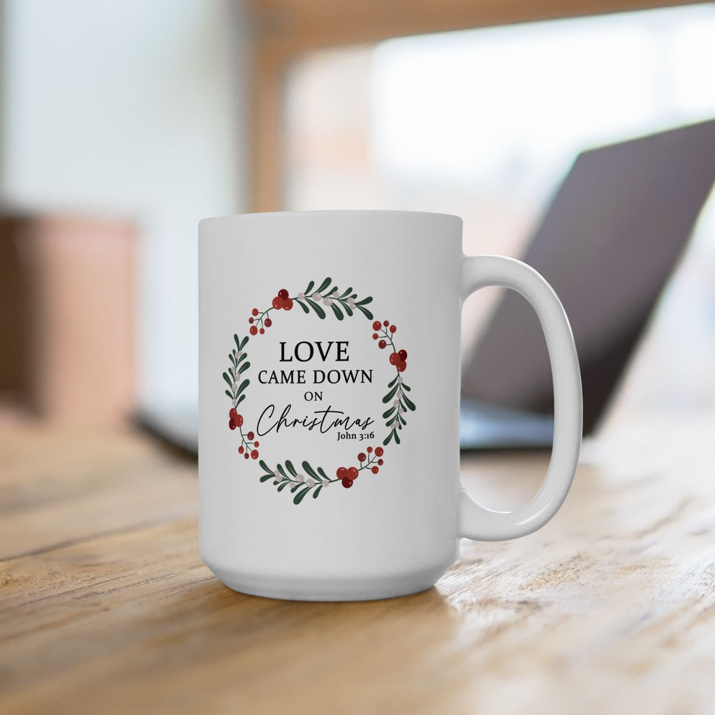 Love Came Down on Christmas 15 oz Christian Christmas Mug - makes for a great Office Christmas Party Gift - in front of a laptop.